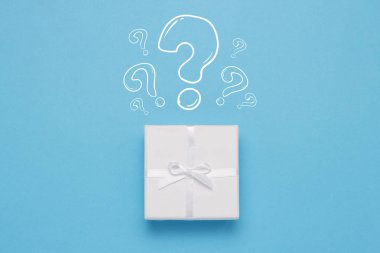 Beyaz hediye kutusu ve simge soru işareti mavi bir arka plan üzerinde. Minimalist tarzı. Kavram sürpriz ve gerilim. Düz yatıyordu, en iyi görünümü.