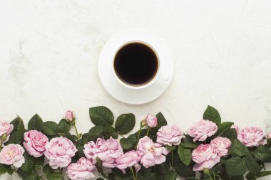 Pembe gül, beyaz bir ışık taş zemin üzerine siyah kahve fincanla. düz yatıyordu, en iyi görünümü.