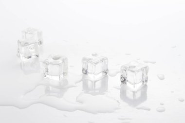 Hafif bir arka plan üzerine dökülen su ve buz küpleri.