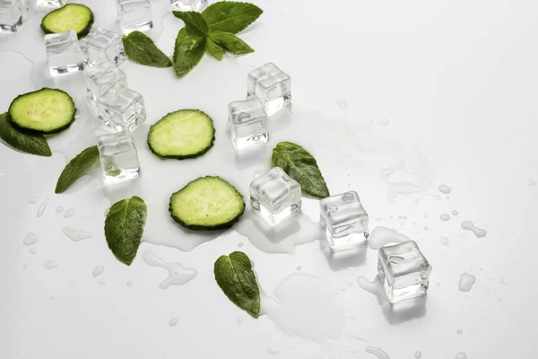 Verschüttetes Glas Mit Erfrischendem Wasser Gurkenscheiben Minzblättern Und Eiswürfeln Auf — Stockfoto
