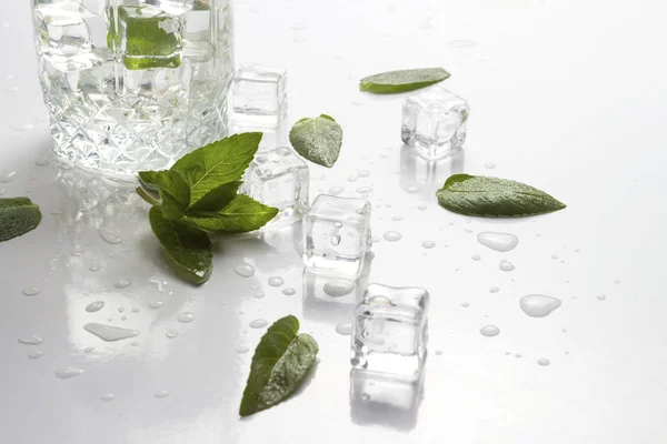Glas Mit Erfrischendem Wasser Minzblättern Wassertropfen Und Eiswürfeln Auf Hellem — Stockfoto
