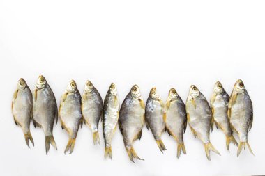 Kurutulmuş balık beyaz bir arka plan üzerinde üst üste dizilmiş. Düz yatıyordu, en iyi görünümü.