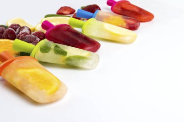 Ev yapımı necklac parlak çilek, kiraz, limon, portakal, limon ve nane ile buzlu şeker meyve ve hafif beyaz zemin üzerine taze meyve dilimleri.