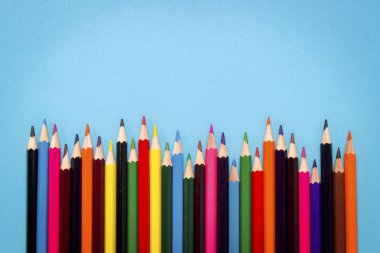 Renkli kalemler mavi bir arka plan bir dalga şeklinde ortaya koydu. Düz yatıyordu, en iyi görünümü.