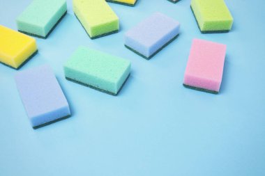 Temizleme Aksesuarları, sünger vardır rasgele mavi bir arka plan üzerinde dağınık. temizlik hizmet anlayışı. Düz yatıyordu, en iyi görünümü.