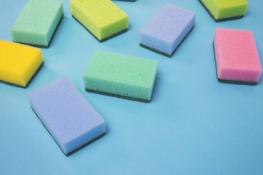 Temizleme Aksesuarları, sünger vardır rasgele mavi bir arka plan üzerinde dağınık. temizlik hizmet anlayışı. Düz yatıyordu, en iyi görünümü.