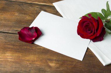 Kırmızı gül ahşap bir masa üzerine beyaz bir kumaş üzerinde. Romantik kavramı. Düz yatıyordu, en iyi görünümü 