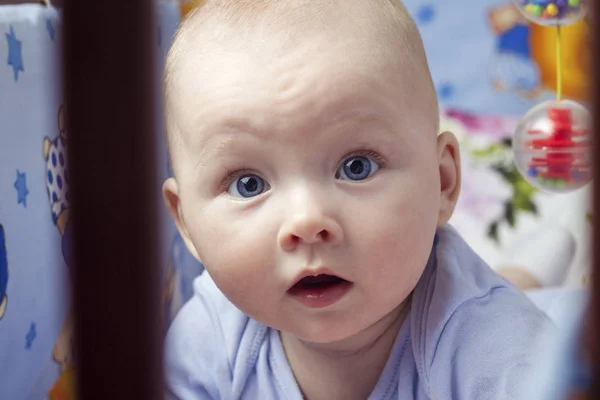 Маленький Ребенок Красивым Лицом Голубыми Глазами Лежит Животе Детской Кроватке — стоковое фото