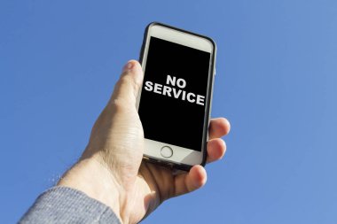Elini bir telefon tutarak ve mavi gökyüzüne karşı bir bağlantı bulmaya çalışıyorum. Telefon ekranında, sinyal simgesi.