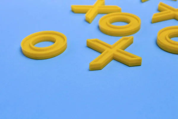 Yellow Plastic Crosses Zeroches Playing Tic Tac Toe Blue Background — Stock Photo, Image