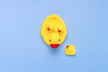 Kauçuk oyuncak sarı renk anne ördek ve mavi bir arka plan üzerinde küçük ördek yavrusu. Üvey çocuk evlat edinme kavramı. Düz yatıyordu, en iyi görünümü.