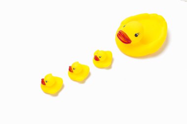 Kauçuk oyuncak sarı renk anne ördek ve beyaz bir arka plan üzerinde küçük ördek yavrusu. Anne bakım ve çocuklar için aşk kavramı.