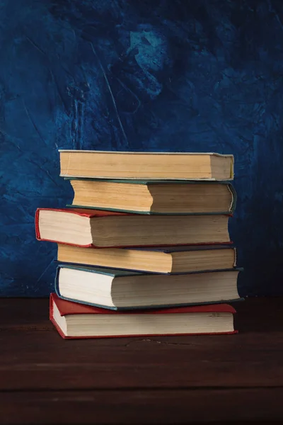 Stoh Knih Dřevěný Stůl Tmavě Modrým Pozadím — Stock fotografie
