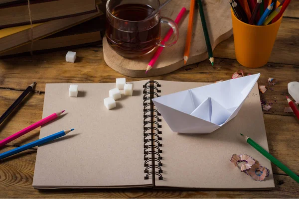 木製のテーブルにお茶の紙ボート 明確なスケッチ ブック 色鉛筆 コップ — ストック写真