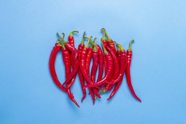 Mavi bir arka plan üzerinde kırmızı sıcak biber biber. Düz yatıyordu, en iyi görünümü.