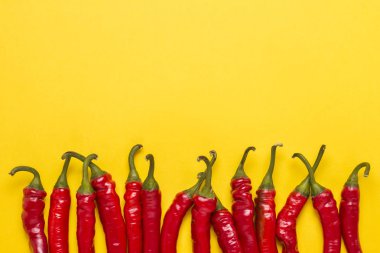 Top yeşil kırmızı sıcak Şili Biber sarı bir arka plan üzerinde kuyrukları. Düz yatıyordu, en iyi görünümü.