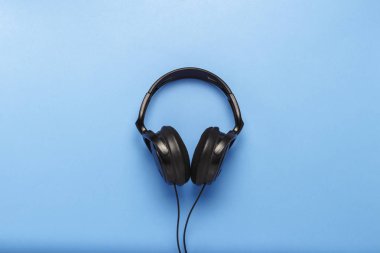 Mavi bir arka plan üzerinde siyah kulaklık. Düz yatıyordu, en iyi görünümü.