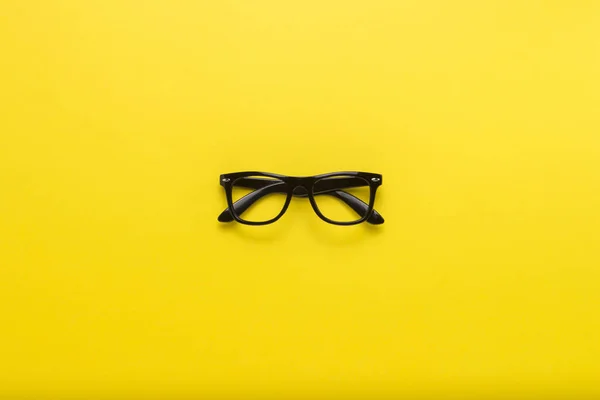 Gafas Negras Sobre Fondo Amarillo Piso Tendido Vista Superior — Foto de Stock