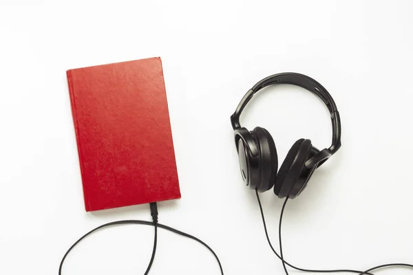 Boek Met Een Rode Zwarte Hoofdtelefoon Een Witte Achtergrond Concept — Stockfoto