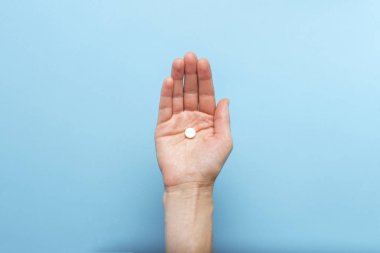 Bir tablet üzerinde mavi bir arka plan avuç üzerinde tutan eller. Hastalık ve hastalık halinde ilaçlar kavramı. Düz yatıyordu, en iyi görünümü.