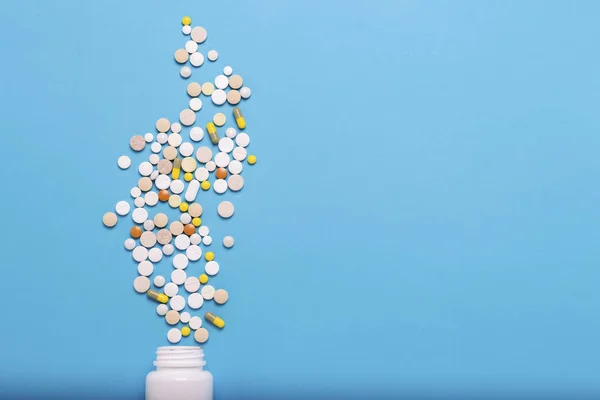 Garrafa Branca Pílulas Multicoloridas Fundo Azul Conceito Produtos Farmacêuticos Medicamentos — Fotografia de Stock