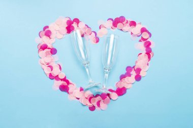 Pembe konfeti bir kalp ve şampanya mavi bir arka plan üzerinde için boş kısımları şeklinde. Parti ve tatil kavramı. Düz yatıyordu, en iyi görünümü.