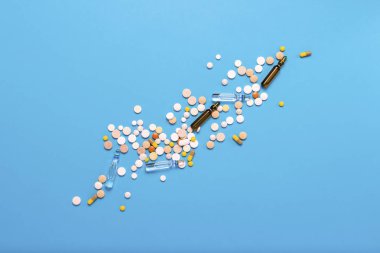 Farklı renkler ve ampul ile mavi bir arka plan üzerinde tıp hapları. İlaç endüstrisi, tıp, tedavi ve kurtarma hastalıktan sonra kavramı. Düz yatıyordu, en iyi görünümü.