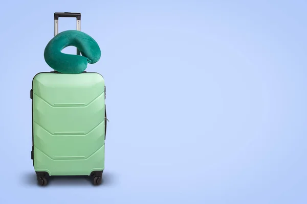 在蓝色背景的塑料手提箱和旅行枕头 旅行的概念 商务旅行 拜访亲友的旅行 — 图库照片