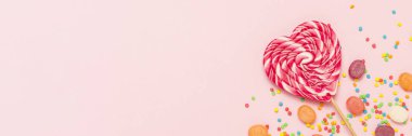 Kalp lolipop ve birden çok tatlılar yavaşça pembe bir arka plan üzerinde renkli. Tatlı ve şekerleme kavramı. Tatlı hediye. Tatlı aşk. Afiş. Düz yatıyordu, en iyi görünümü.
