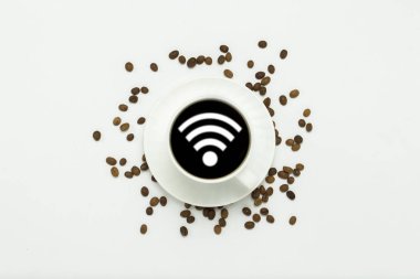 bir uçan daire ve koyu bir kahve ve bir Wifi simgesi, kahve taneleri ile beyaz fincan beyaz bir arka plan üzerinde etrafında dağılmışlardır. Düz yatıyordu, en iyi görünümü.