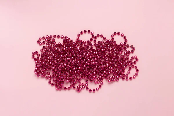Pink garland on a light pink background. Minimalism. The concept of the New Year and Merry Christmas. Flat lay, top view.