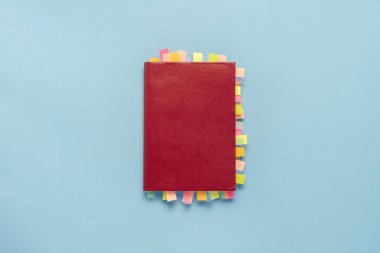 Kırmızı günlüğü ile mavi arka plan sayfalarında çıkartmaları. Bir başarılı bir iş, doğru planlama, zaman yönetimi kavramı. Düz yatıyordu, en iyi görünümü.