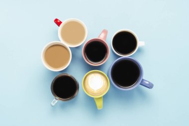 Mavi bir arka plan üzerinde kahve ve kahve içecekleri çok çok renkli bardak. Kavram kahvaltı kahve, kahve arkadaş grubu. Düz yatıyordu, en iyi görünümü.