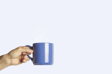 Mavi bir arka plan mavi bir bardakta tutan el. Yan görünüm.
