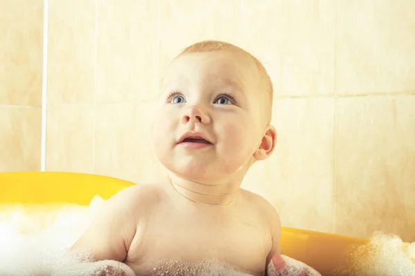 Das Kleine Baby Badet Einem Gelben Bad Mit Blasen Und — Stockfoto