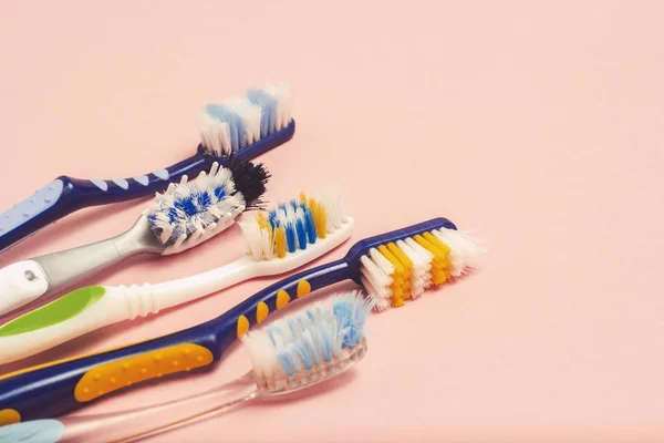 Várias Escovas Dentes Usadas Diferentes Fundo Rosa Conceito Mudança Escova — Fotografia de Stock