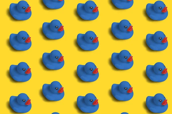 Pattern of blue toy ducks on a yellow background. Concept for background, napkins, wrapping paper