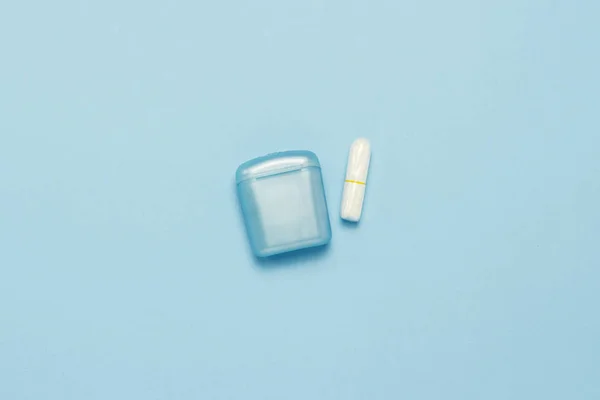 Feminine hygiene tampons and box for shipping and storage on a blue background. Concept of feminine hygiene during menstruation, critical days. Flat lay, top view