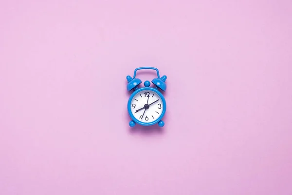 蓝色闹钟在粉红色的背景 概念日夜 时间管理 日以继夜的时间表 极简主义 平面布局 顶部视图 — 图库照片