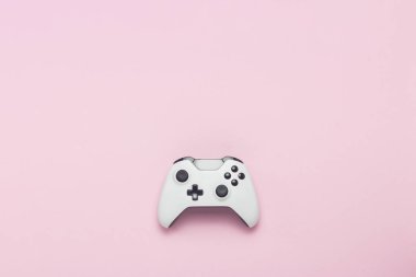 Pembe bir arka plan beyaz gamepad. Konsolda, bilgisayar oyunları kavramı oyun. Düz yatıyordu, en iyi görünümü
