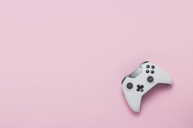 Pembe bir arka plan beyaz gamepad. Konsolda, bilgisayar oyunları kavramı oyun. Düz yatıyordu, en iyi görünümü