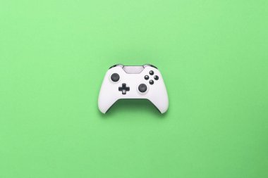 Yeşil bir arka plan üzerinde beyaz gamepad. Konsolda, bilgisayar oyunları kavramı oyun. Düz yatıyordu, en iyi görünümü