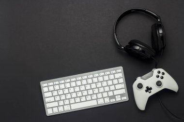 Klavye, gamepad ve kulaklık siyah bir arka plan. Konsolda, oyun kavramını oyun. Düz yatıyordu, en iyi görünümü.