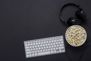 Klavye, patlamış mısır ve kulaklık siyah bir arka plan ile kase. Oyun, Pc, oyun kavramını film izlerken Tv programları, yarışmalar Pc. düz yatıyordu, üst görünümünde spor