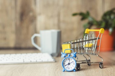 Mini süpermarket arabası, çalar saat ve klavye ofis masasında