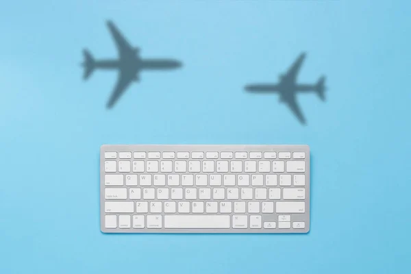 Teclado Sombra Avião Voador Sobre Fundo Azul Conceito Comprar Bilhetes — Fotografia de Stock