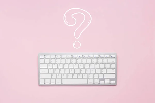 Keyboard on a pink background. Question mark. Concept creative crisis, the difficulties of search. Flat lay, top view