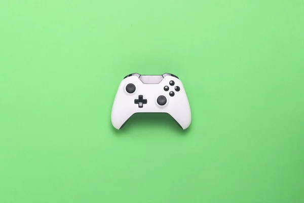 緑の背景に白のゲームパッド コンソール コンピューター ゲームのコンセプトのゲーム フラット横たわっていた トップ ビュー — ストック写真