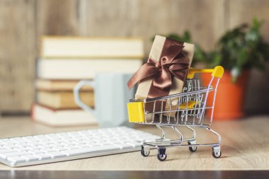 Klavye, çalar saat ve Kupası ofis masasında hediye kutusu ile mini süpermarket arabası