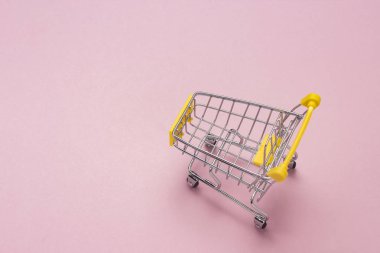 Yalıtılmış bir pembe arka plan üzerinde alışveriş arabası marketten. Alışveriş merkezinde alışveriş, alışveriş, alışveriş. Düz yatıyordu, en iyi görünüm. Kopya alanı